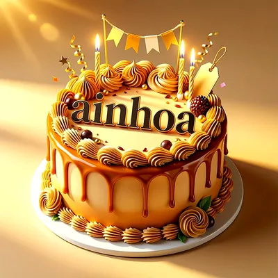 Tarta de cumpleaños dorada con cobertura de caramelo, velas encendidas, banderines y el nombre Ainhoa en letras negras.